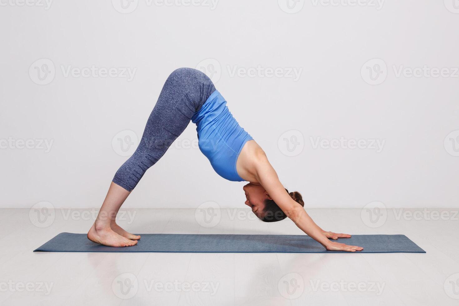 Woman doing Ashtanga Vinyasa yoga asana Adhomukha svanasana photo