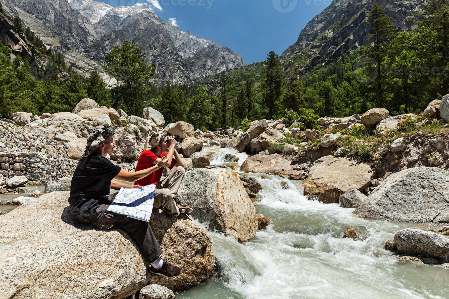 Hikers with map in mountains photo