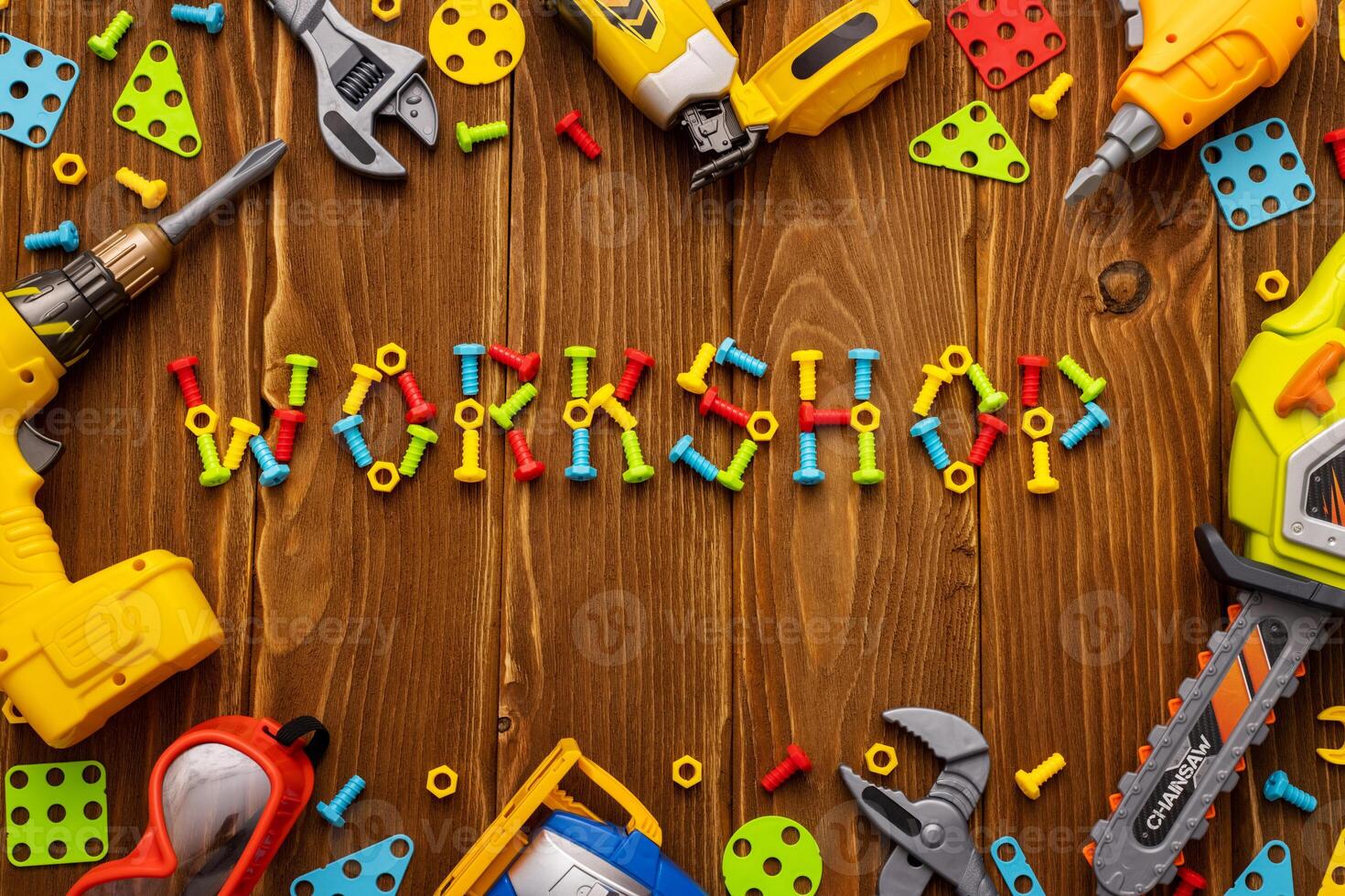 Toy tools, bolts and nuts with text WORKSHOP on wooden background photo