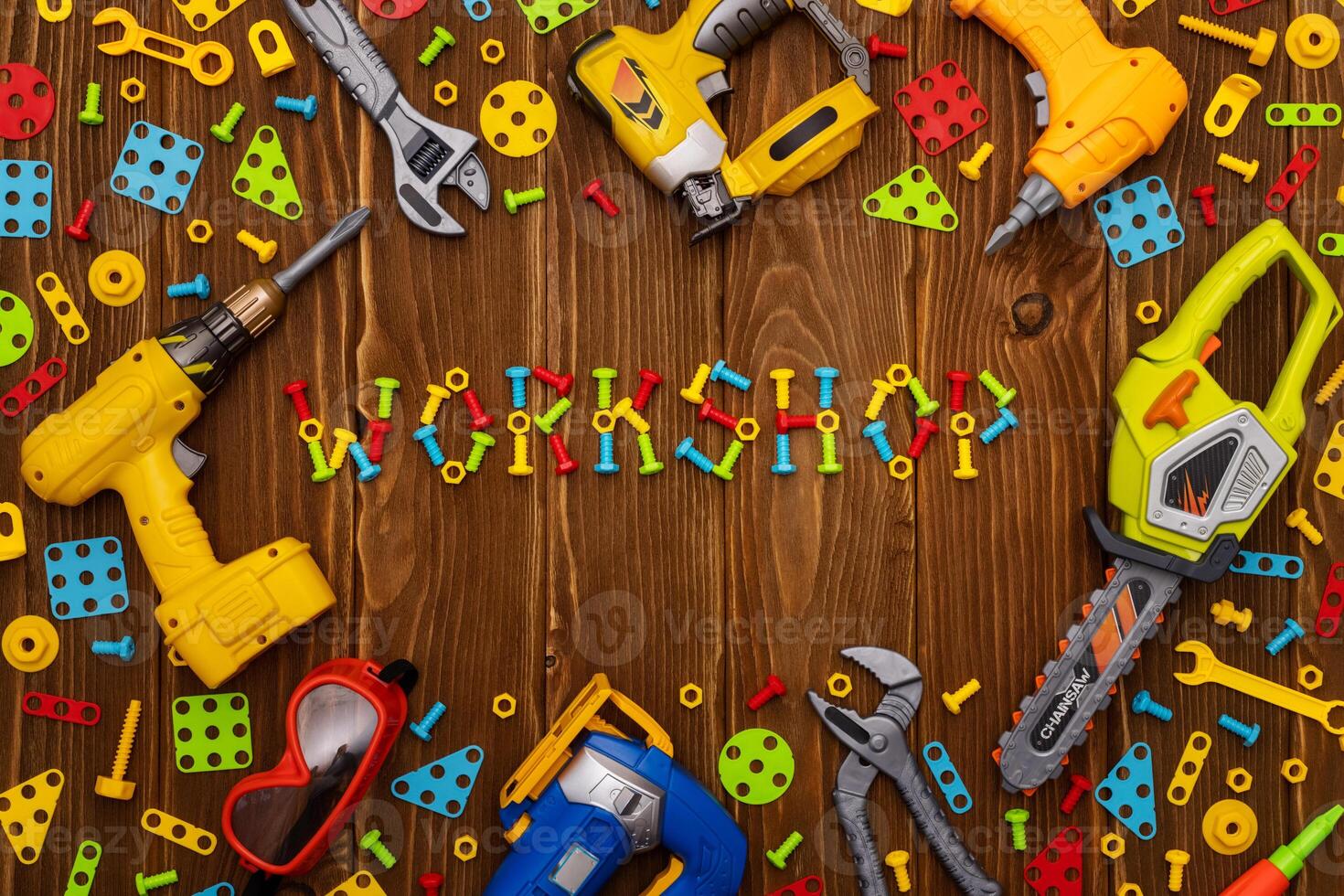 Toy tools, bolts and nuts with text WORKSHOP on wooden background photo