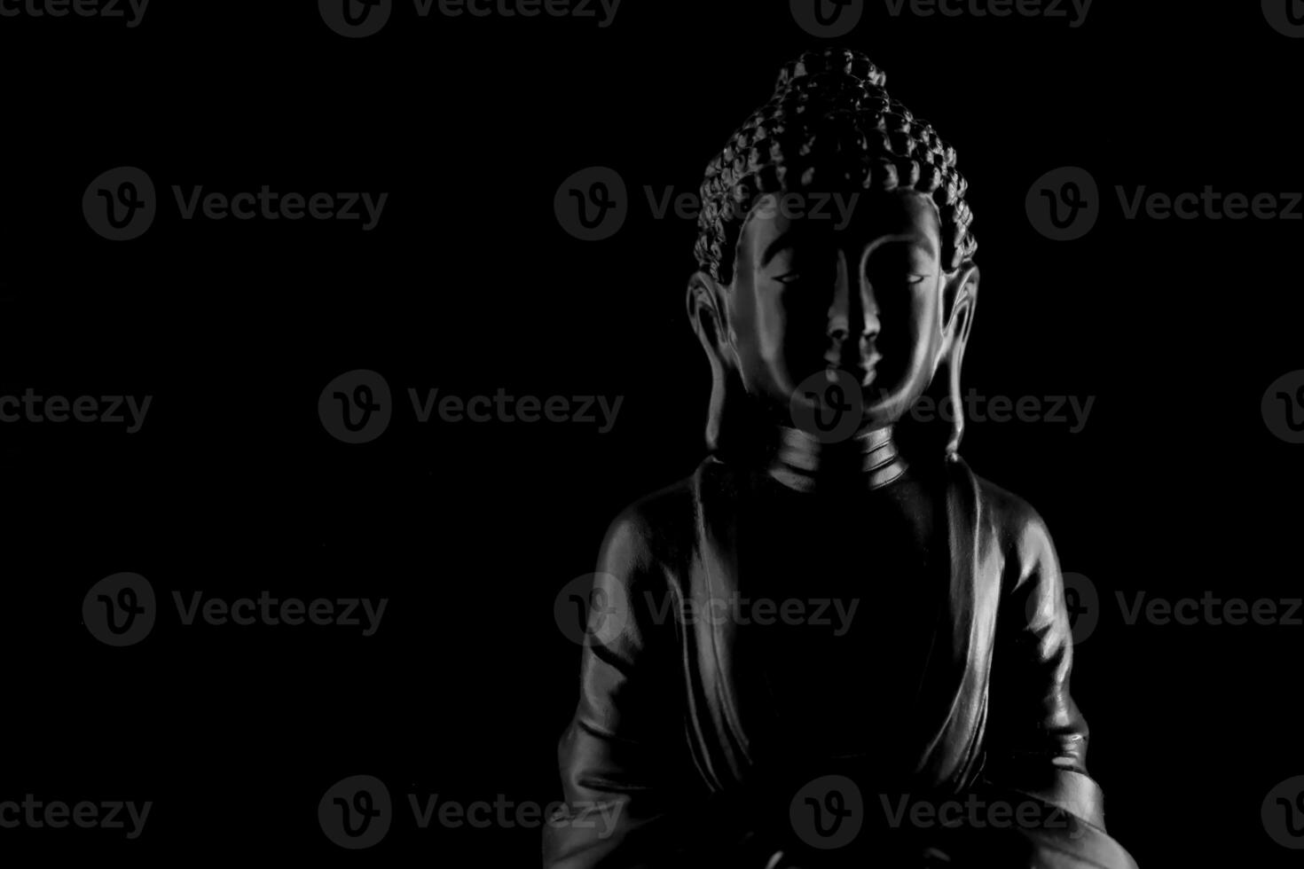 Buddha Purnima and Vesak day concept, Grey Buddha statue with low key light against deep black background photo