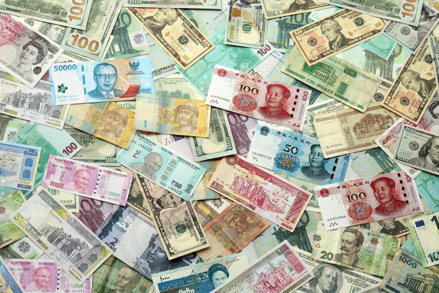 Many banknotes of different currency. Background of big amount of random money bills photo