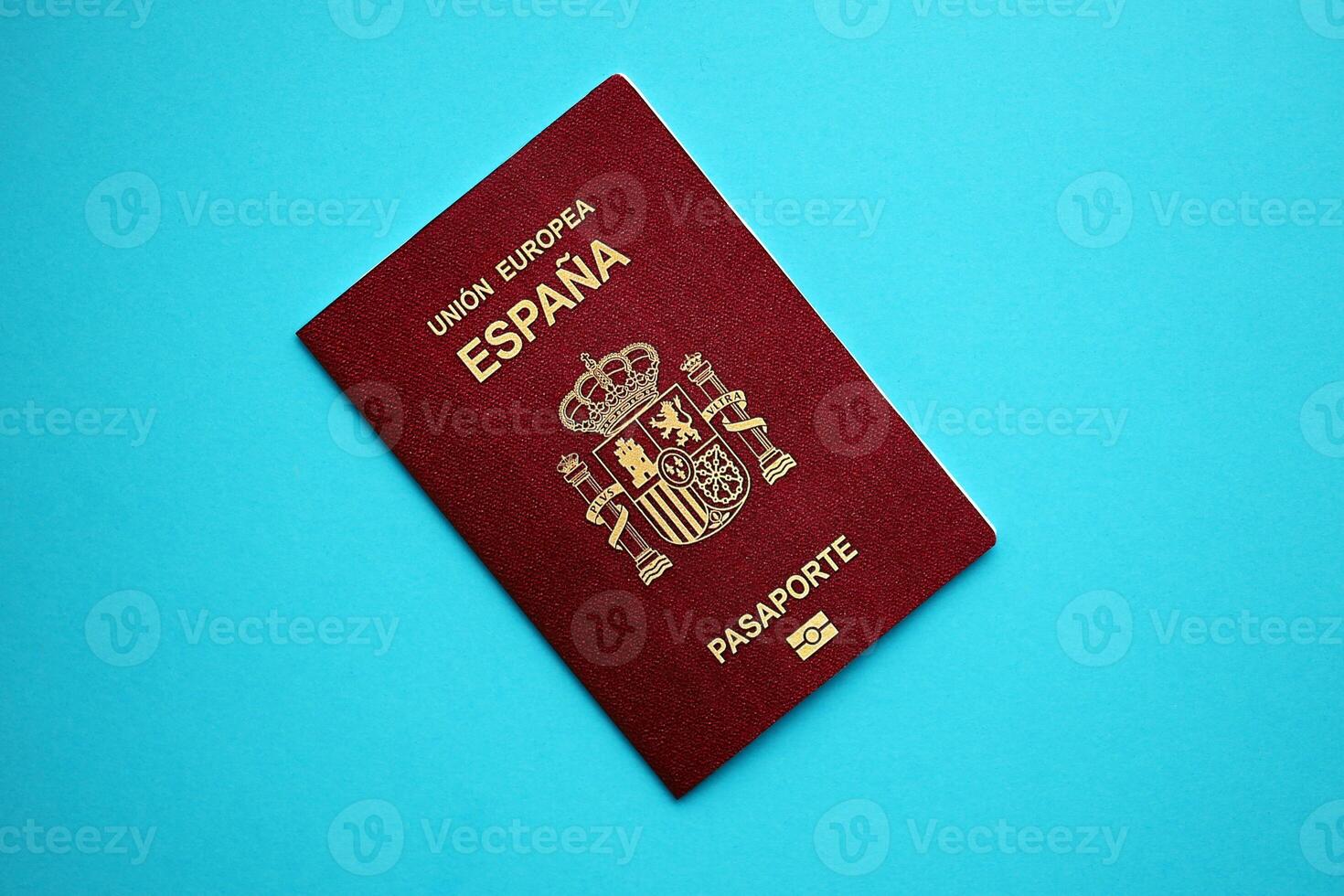 Red Spanish passport of European Union on blue background close up photo