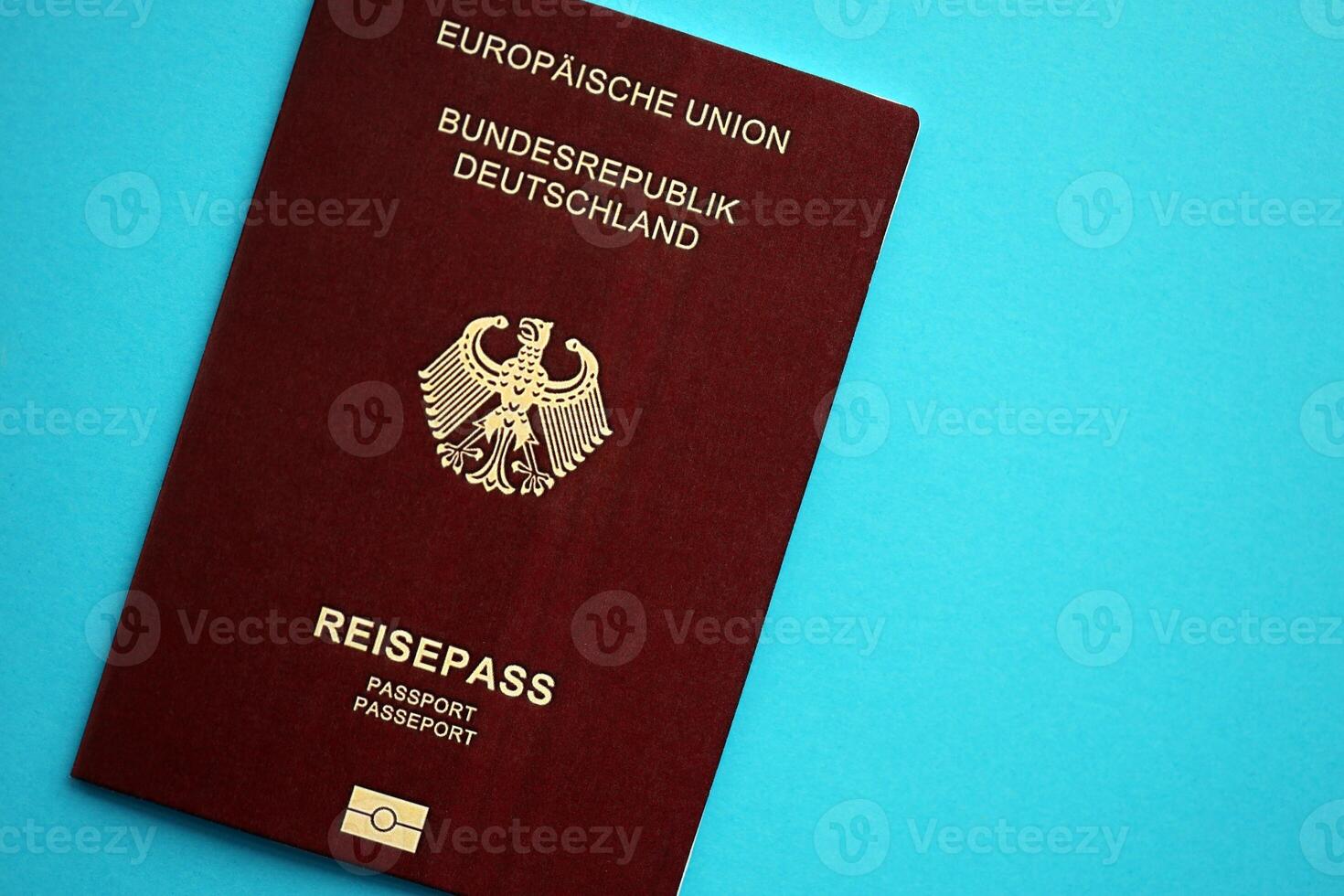 Red German passport of European Union on blue background close up photo