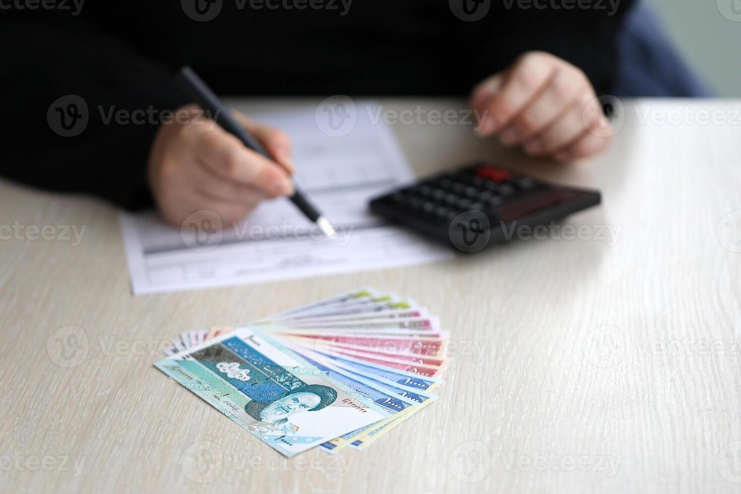 Accountant start to fill Iranian tax form on office table. Taxation period and annual taxpayers routine photo