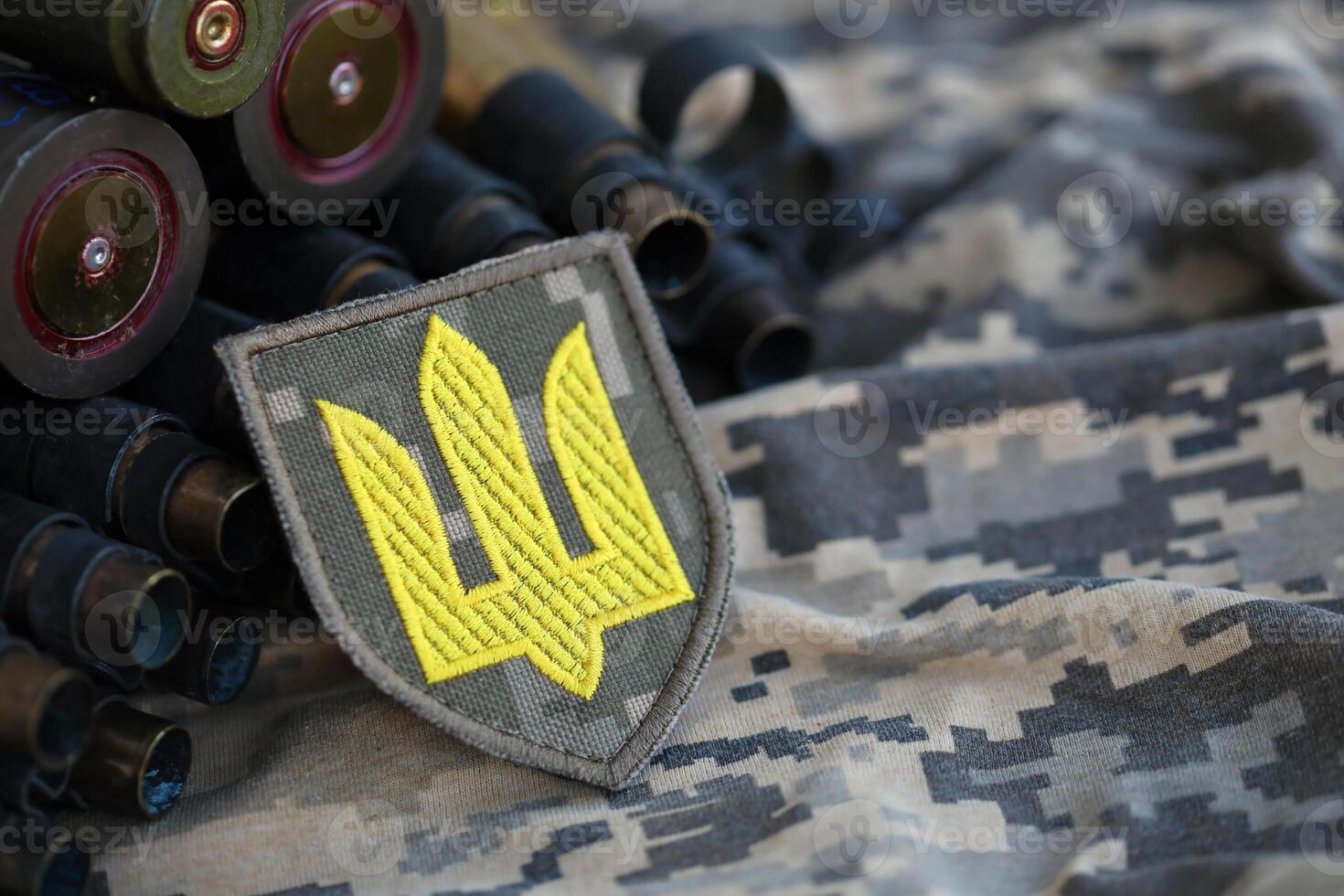 Ukrainian army symbol on machine gun belt lies on ukrainian pixeled military camouflage photo