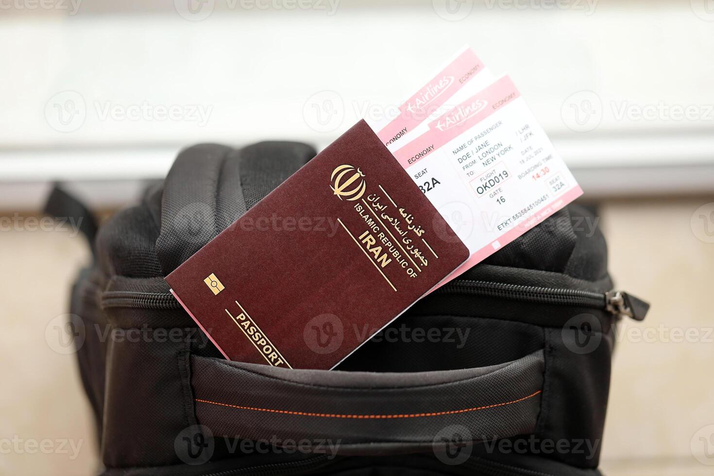 Red Islamic Republic of Iran passport with airline tickets on touristic backpack photo