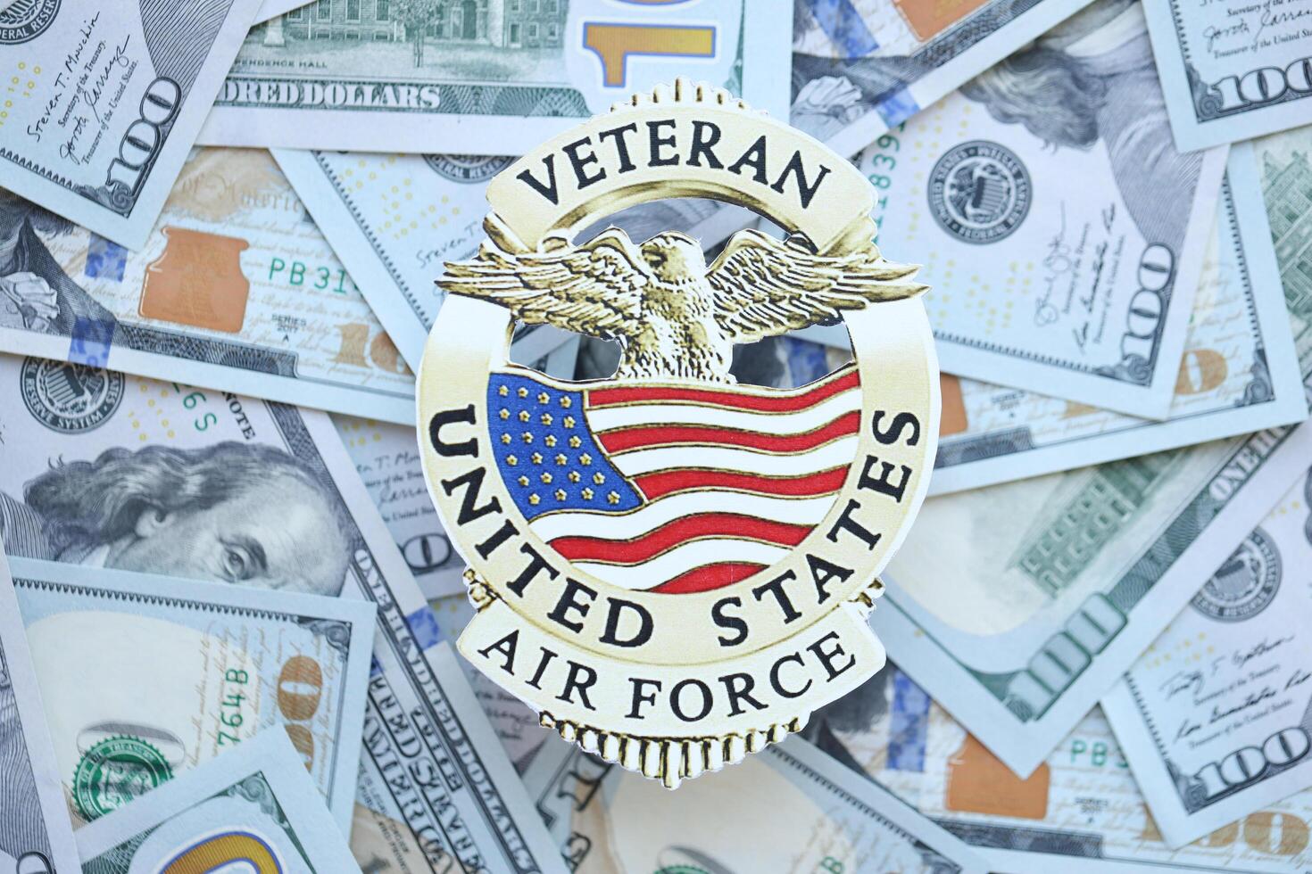 KYIV, UKRAINE - MARCH 9, 2024 US Air Force Veteran badge on many US hundred dollar bills photo