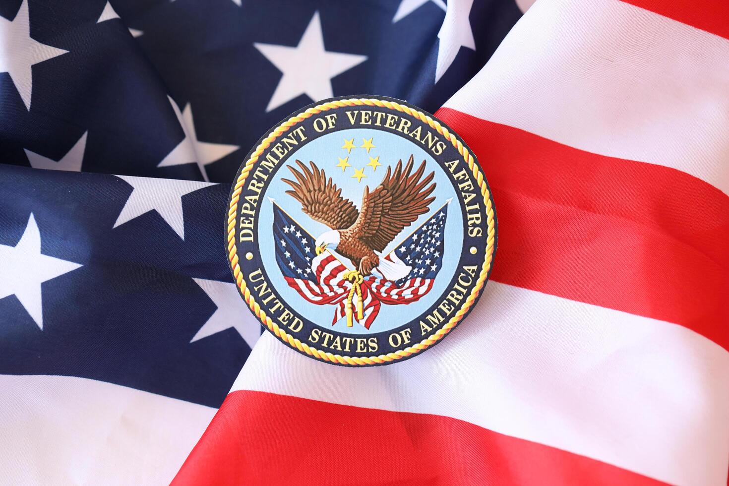 KYIV, UKRAINE - MARCH 9, 2024 US Department of Veteran Affairs seal on United States of America flag photo