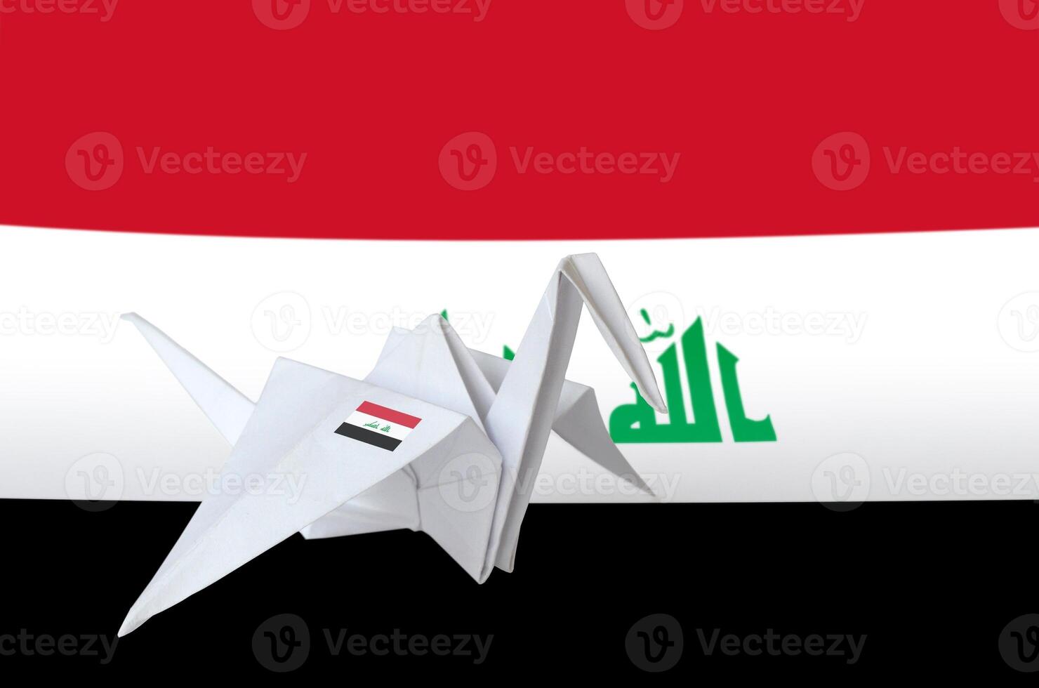 Iraq flag depicted on paper origami crane wing. Handmade arts concept photo