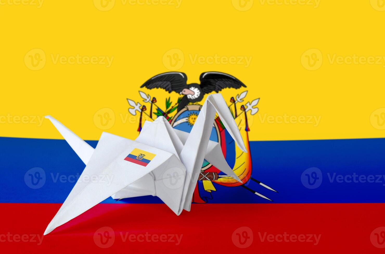 Ecuador flag depicted on paper origami crane wing. Handmade arts concept photo