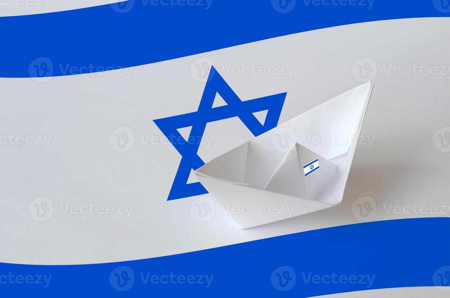 Israel flag depicted on paper origami ship closeup. Handmade arts concept photo