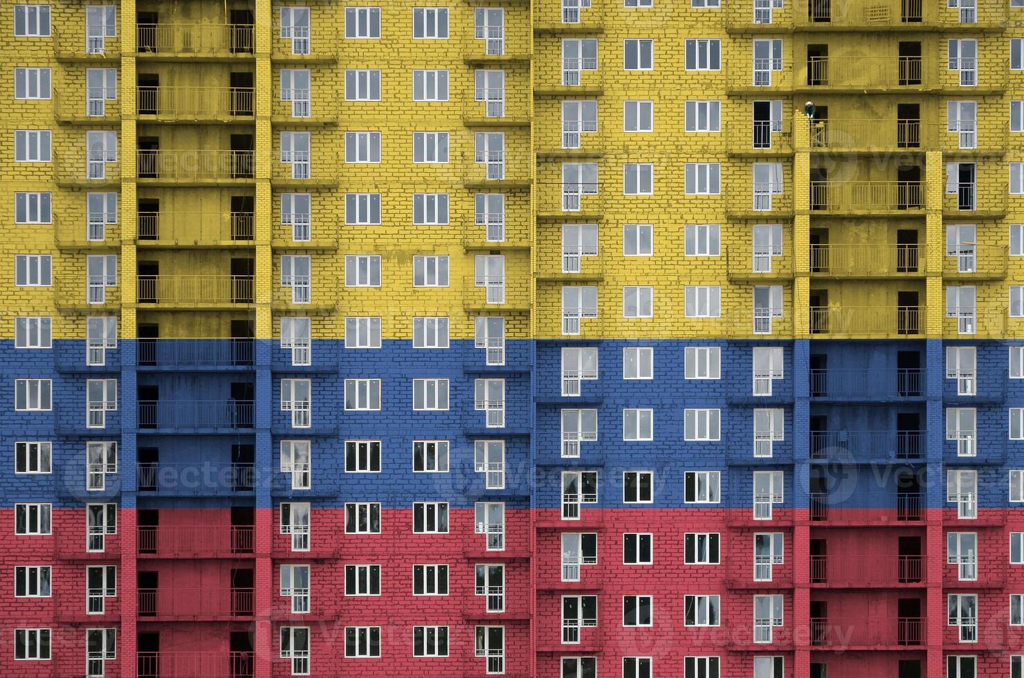 Colombia bandera representado en pintar colores en de muchos pisos residencial edificio debajo construcción. texturizado bandera en ladrillo pared antecedentes foto