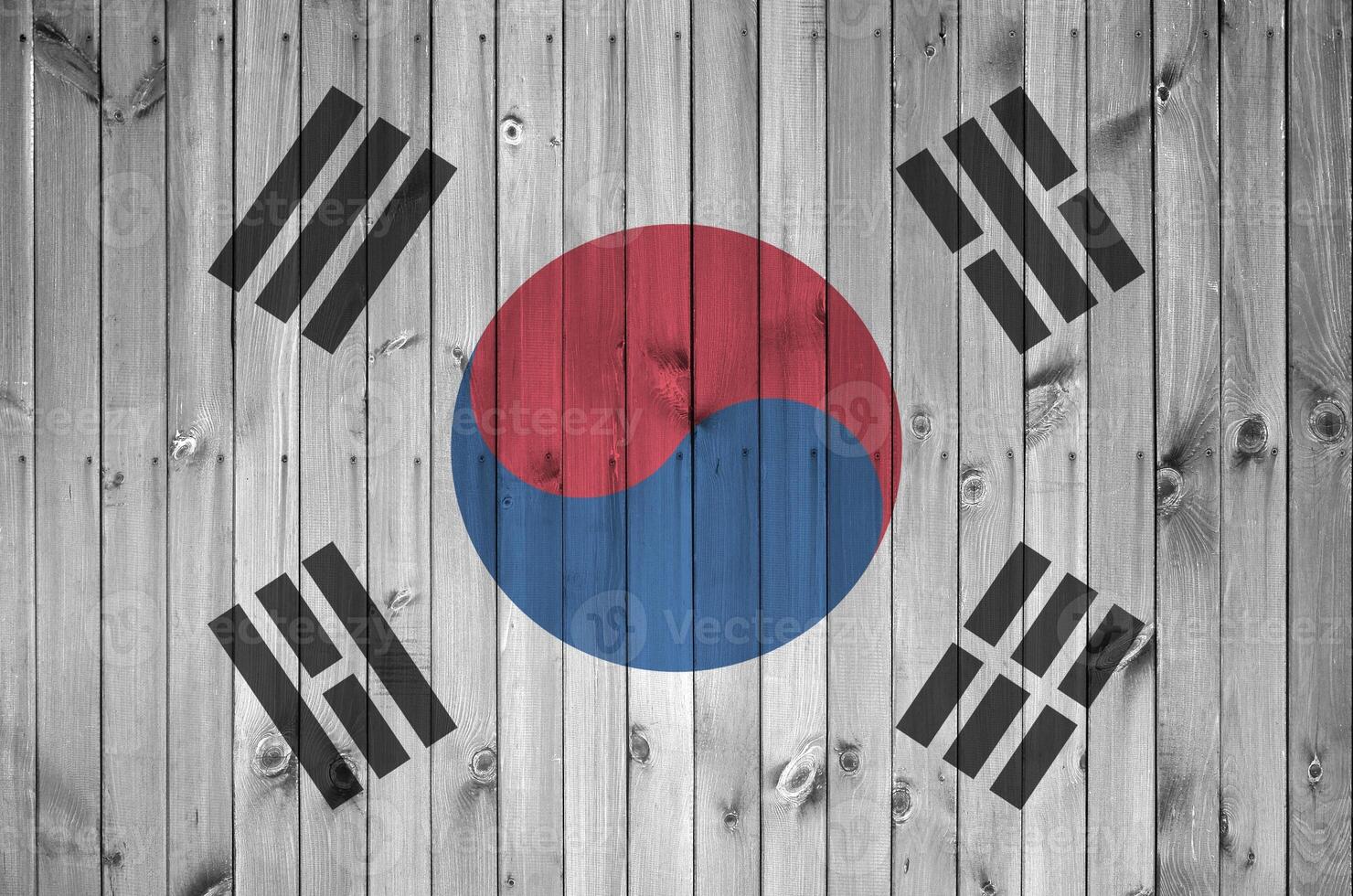 South Korea flag depicted in bright paint colors on old wooden wall. Textured banner on rough background photo