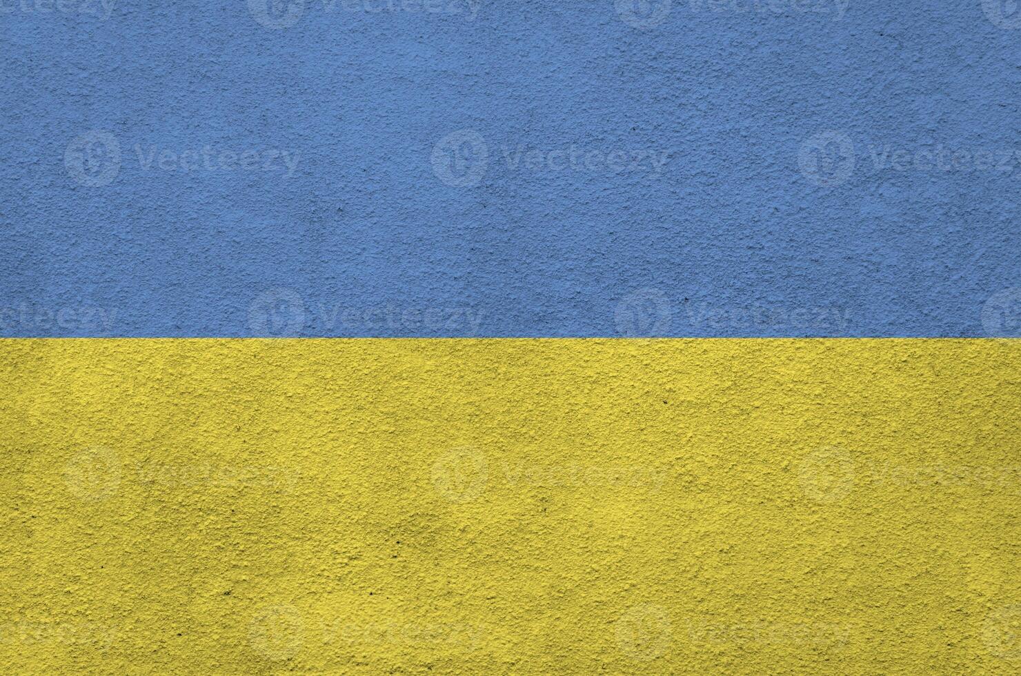 Ukraine flag depicted in bright paint colors on old relief plastering wall. Textured banner on rough background photo