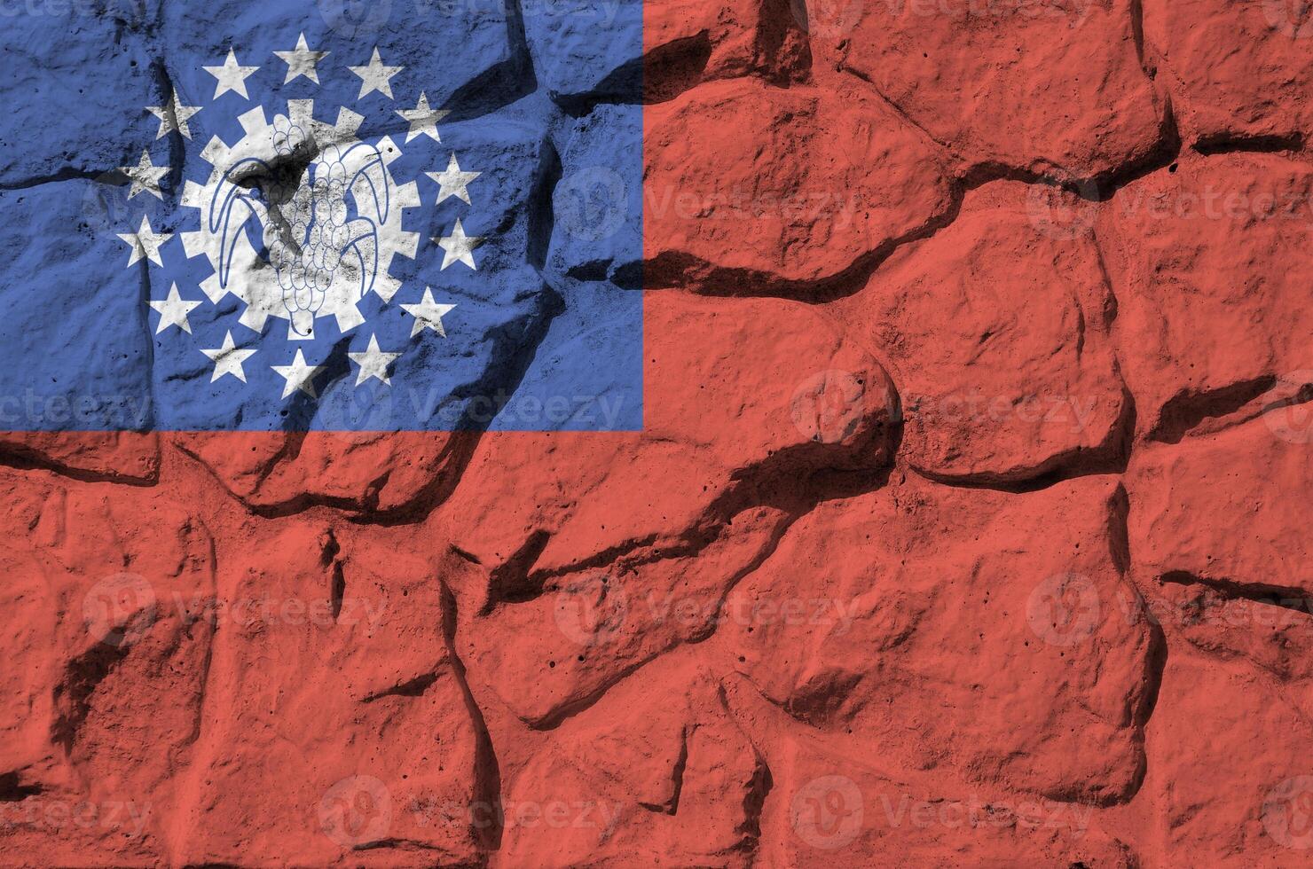 Myanmar flag depicted in paint colors on old stone wall closeup. Textured banner on rock wall background photo