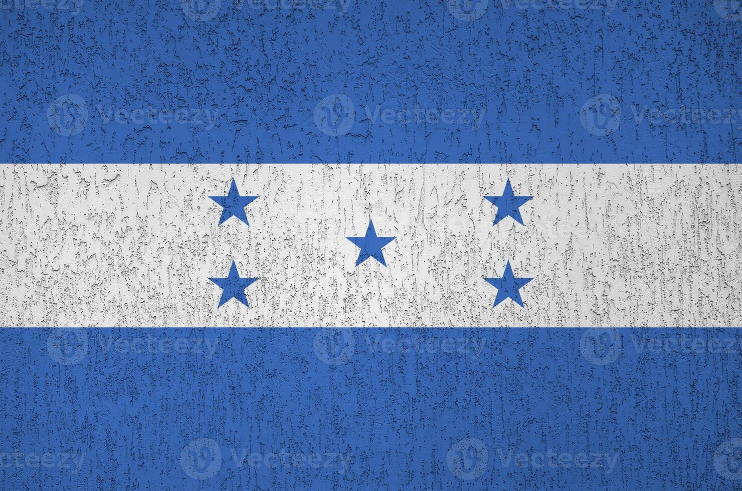Honduras flag depicted in bright paint colors on old relief plastering wall. Textured banner on rough background photo