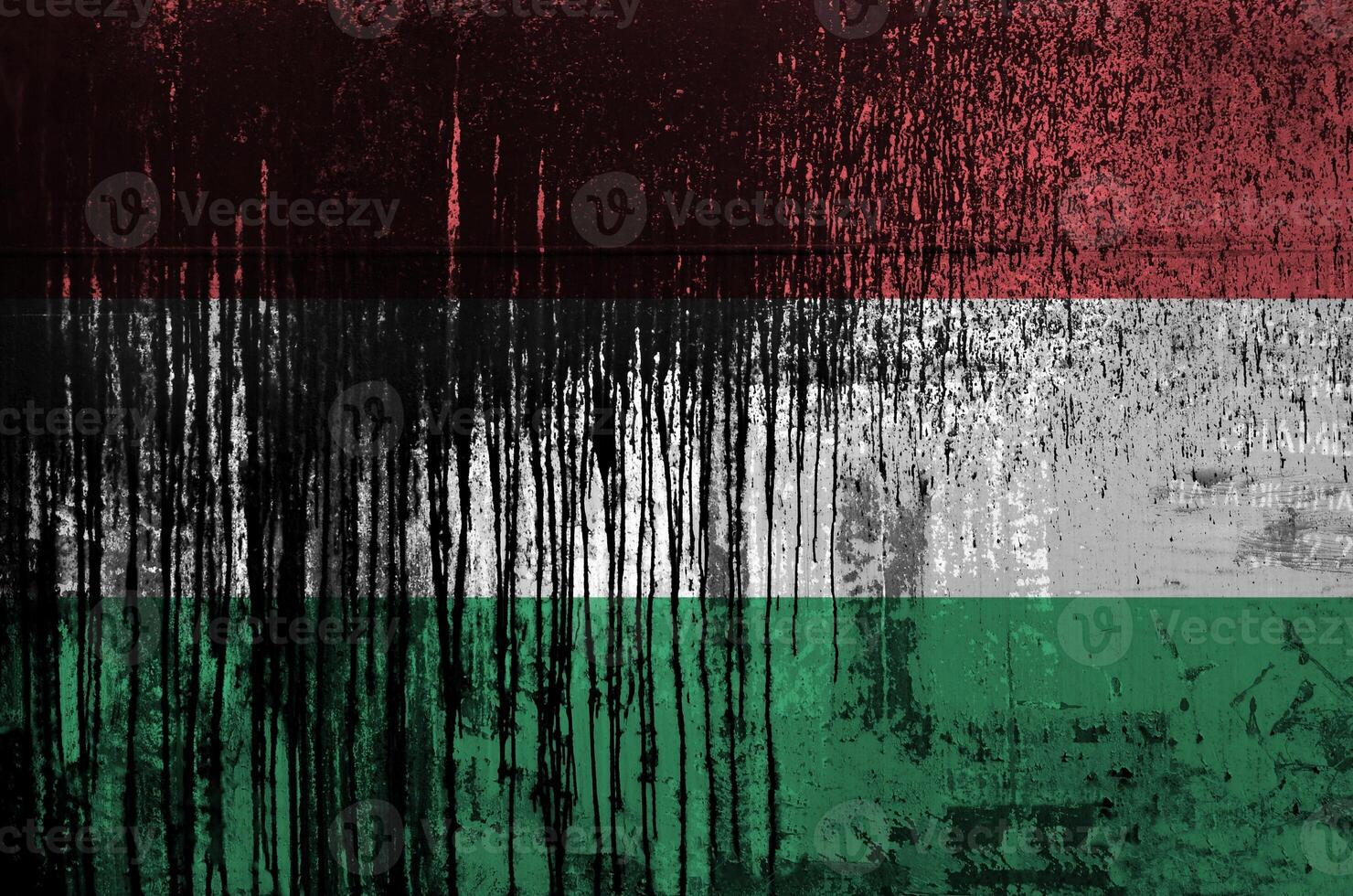 Hungary flag depicted in paint colors on old and dirty oil barrel wall closeup. Textured banner on rough background photo