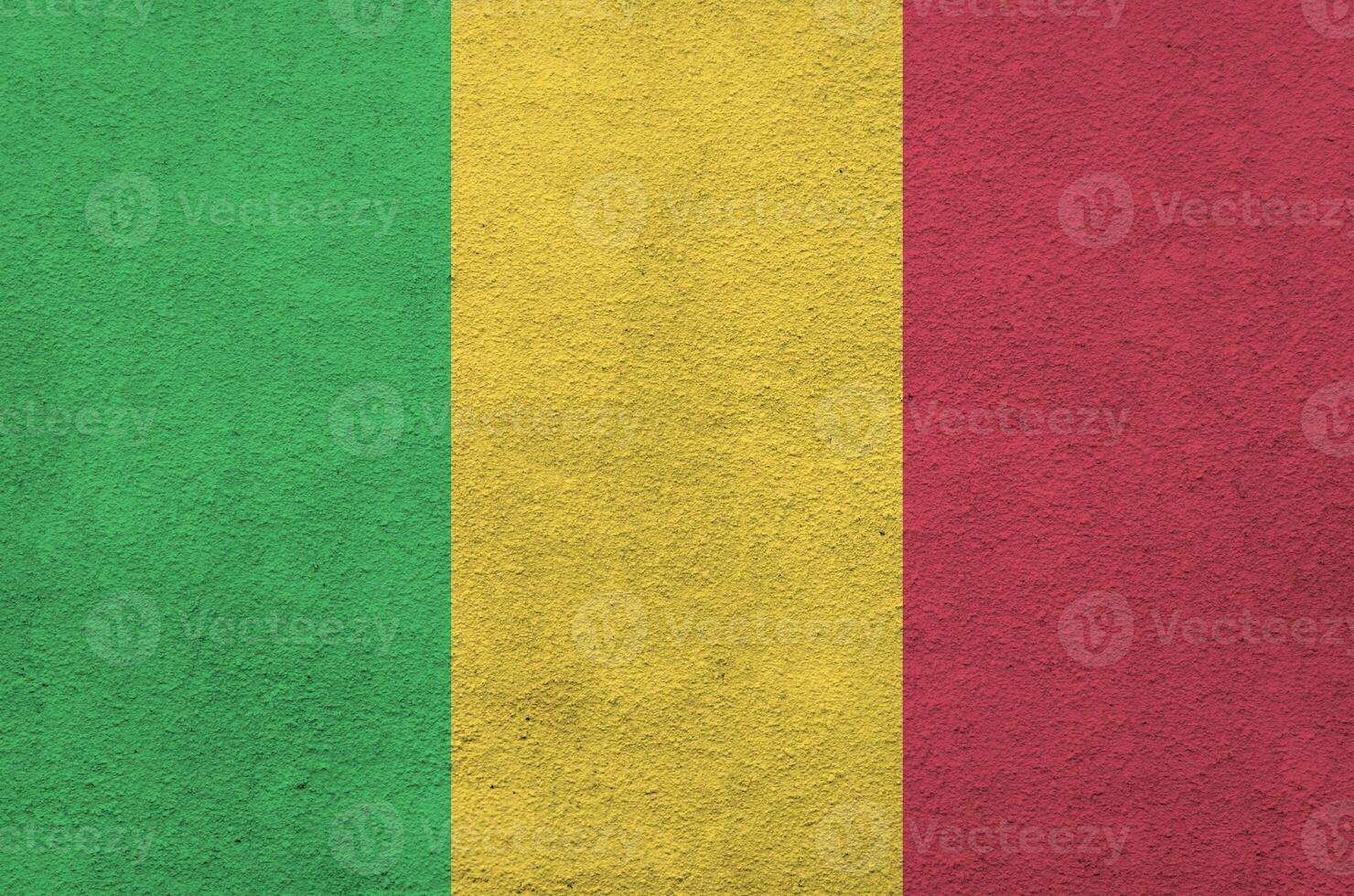 Mali flag depicted in bright paint colors on old relief plastering wall. Textured banner on rough background photo