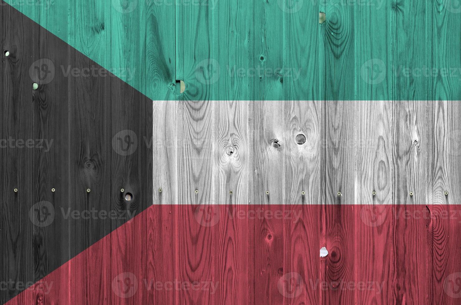 Kuwait bandera representado en brillante pintar colores en antiguo de madera pared. texturizado bandera en áspero antecedentes foto