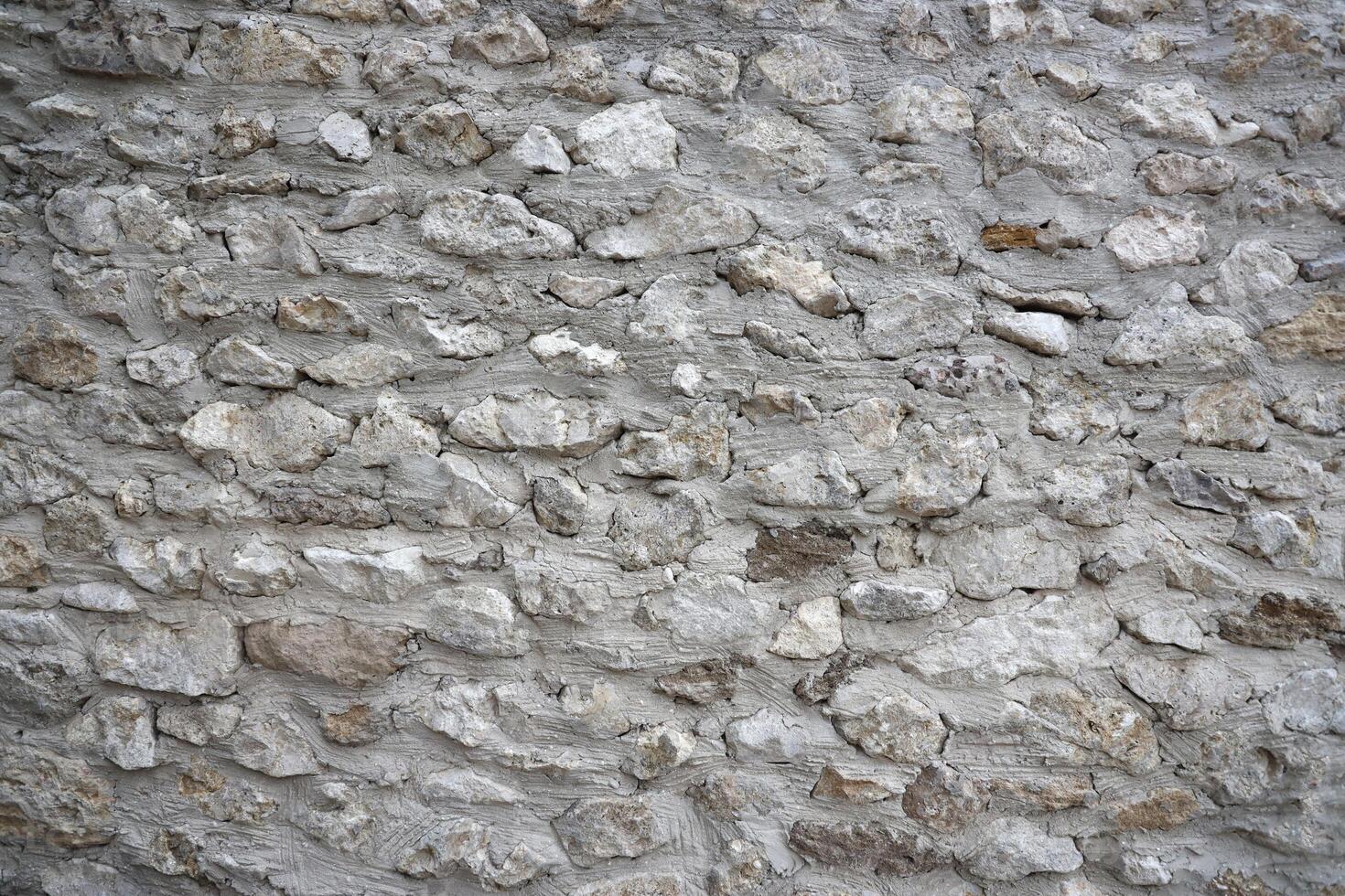 Very old brick stone wall of castle or fortress of 18th century. Full frame wall with obsolete dirty and cracked bricks photo