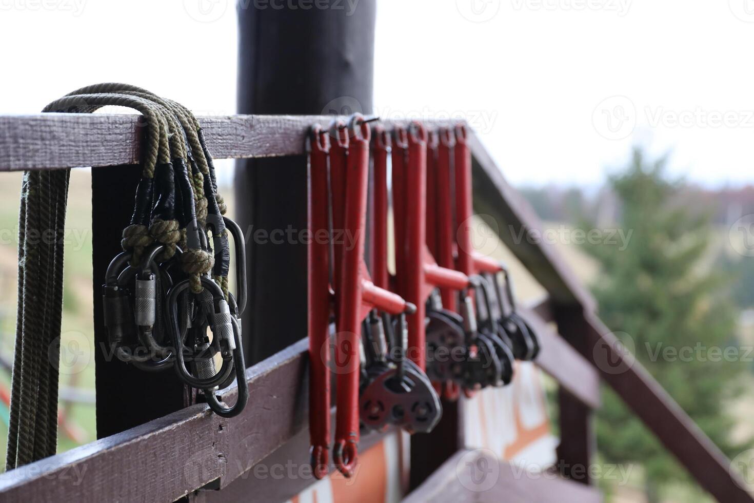 large metal locking carabiners with rope, climbing gear hanging on the store room. Height safety harness and arborist equipment photo
