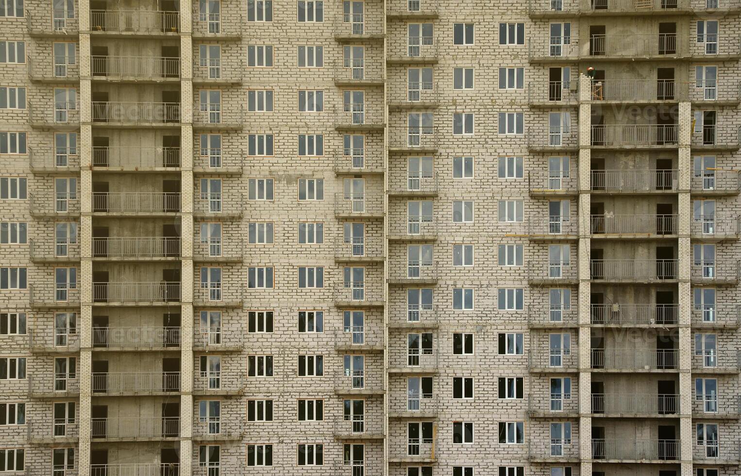 Textured pattern of a russian whitestone residential house building wall with many windows and balcony under construction photo