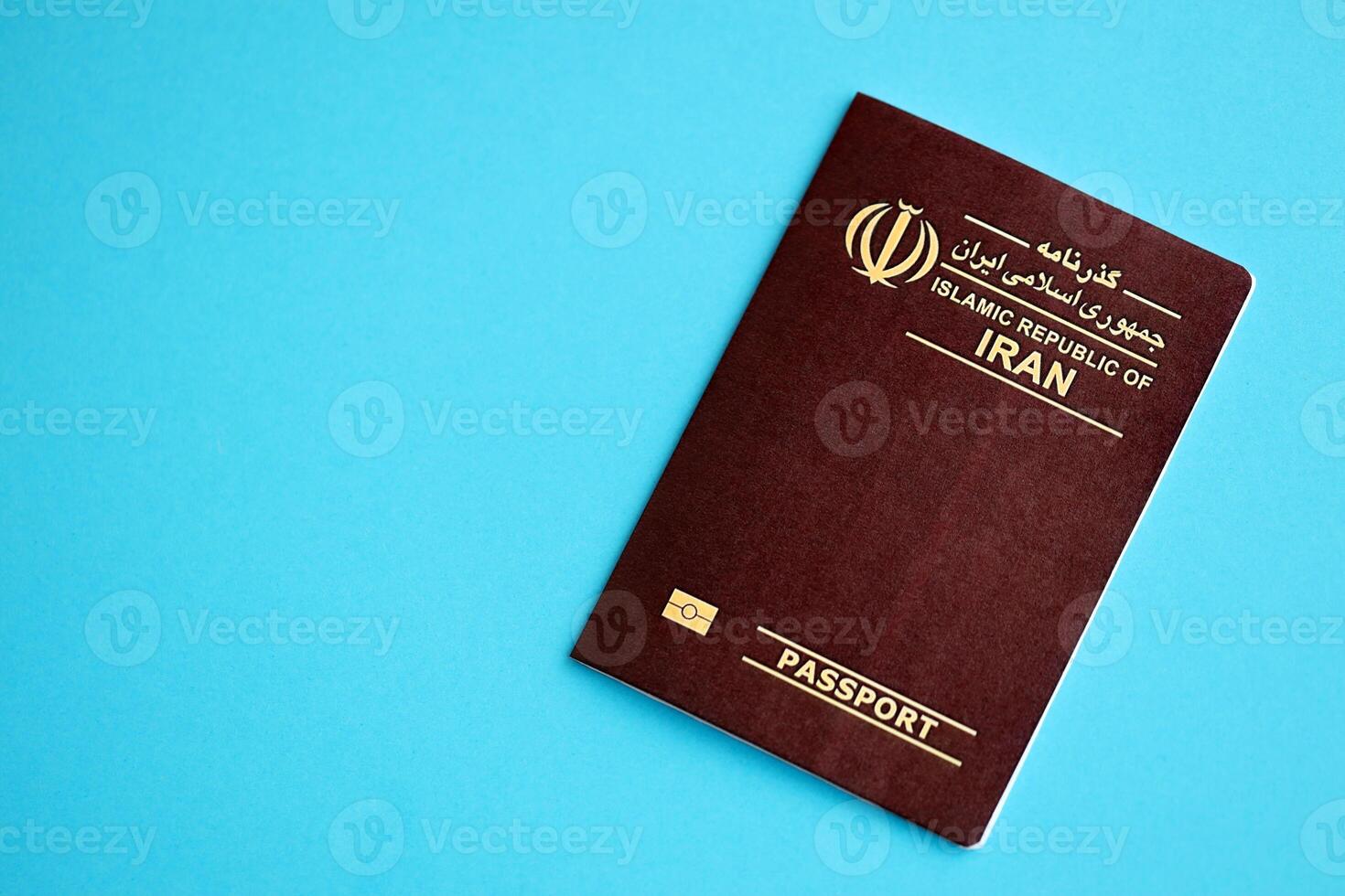 Red Islamic Republic of Iran passport on blue background close up photo