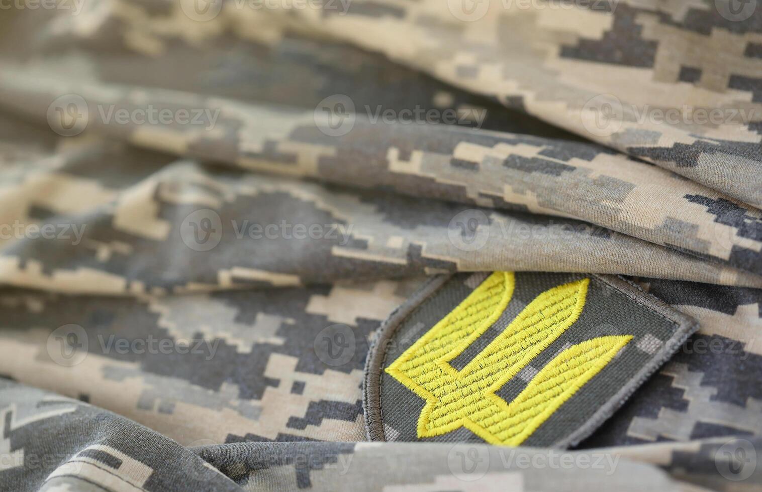 Symbol of Ukrainian army on the camouflage uniform of a Ukrainian soldier. The concept of war in Ukraine, patriotism and protecting your country from occupiers photo