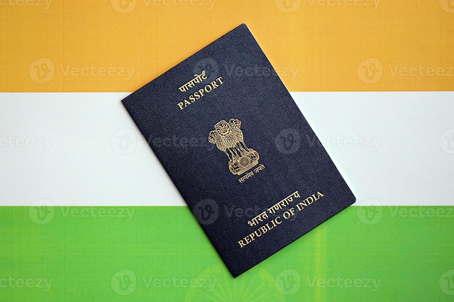 Blue Indian passport on national flag background close up photo