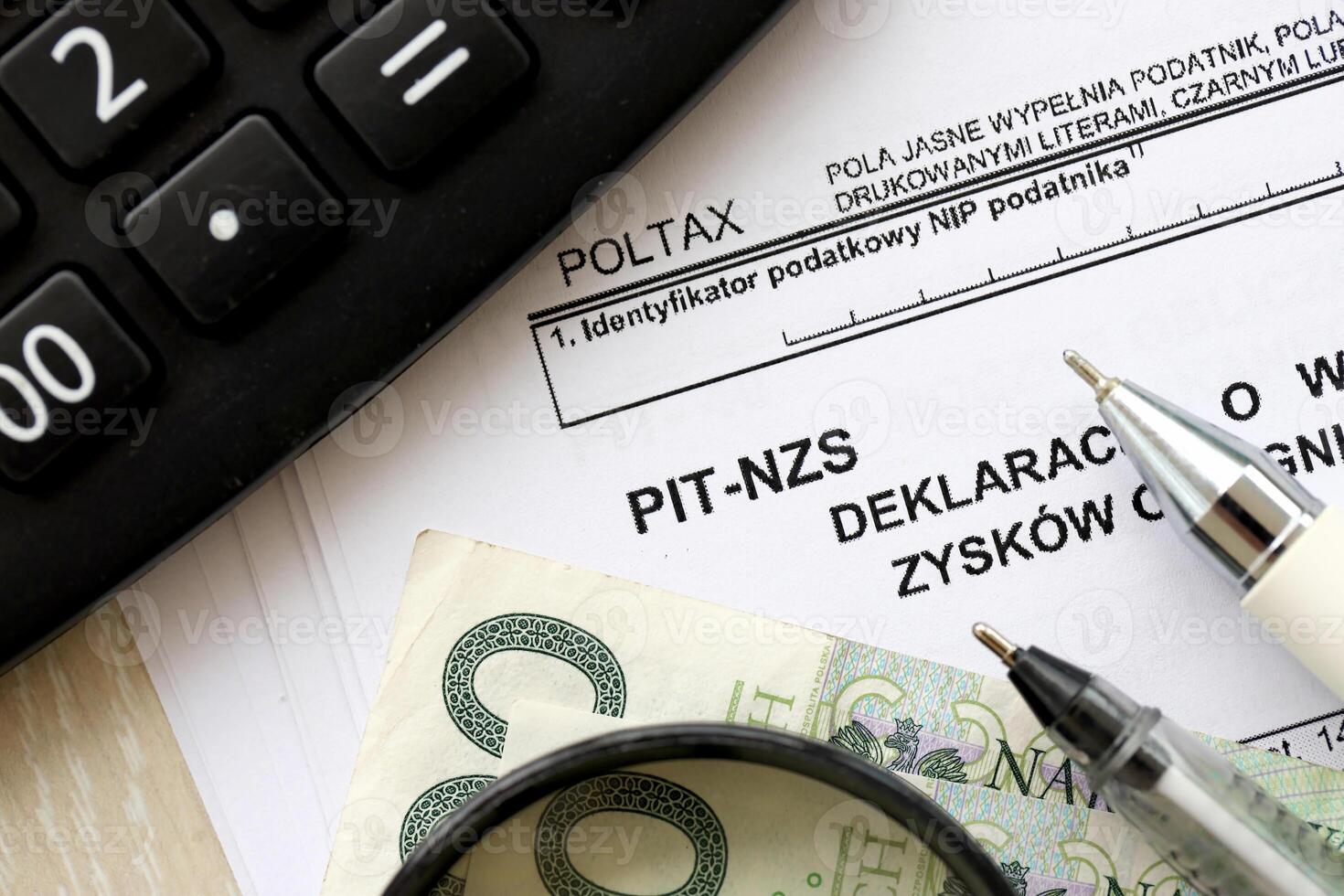 Declaration of income amount from unrealized profits obtained by enterprise as inheritance, PIT-NZS form on accountant table with pen and polish zloty money bills photo
