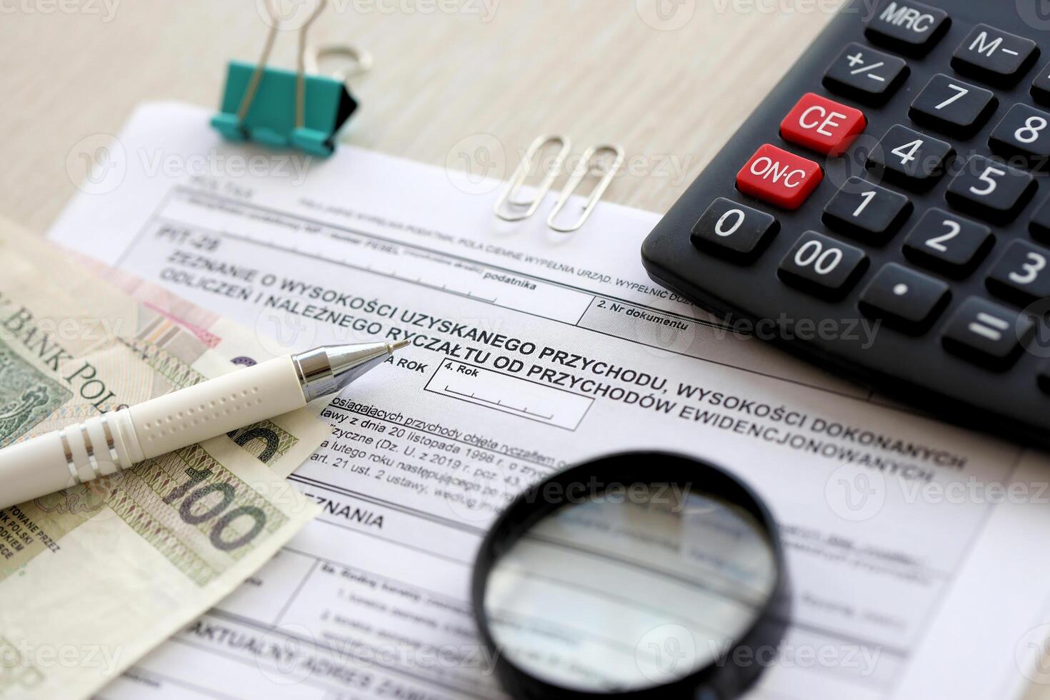 Declaration of amount of income obtained, amount of deductions made and lump sum due from recorded income, PIT-28 form on accountant table with pen and polish zloty money bills photo