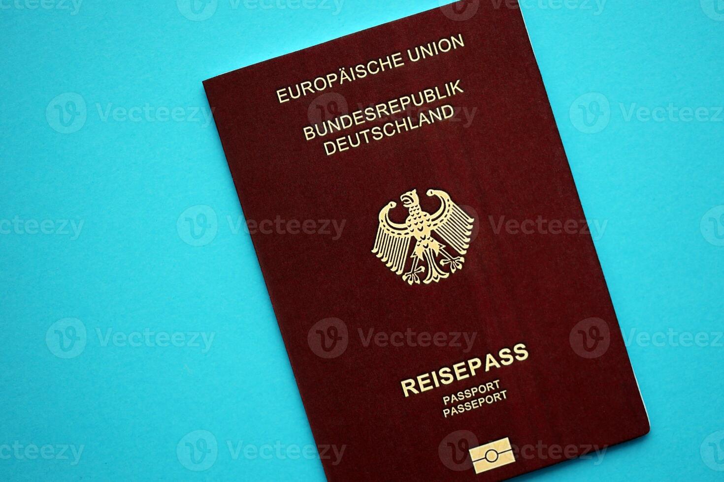 Red German passport of European Union on blue background close up photo