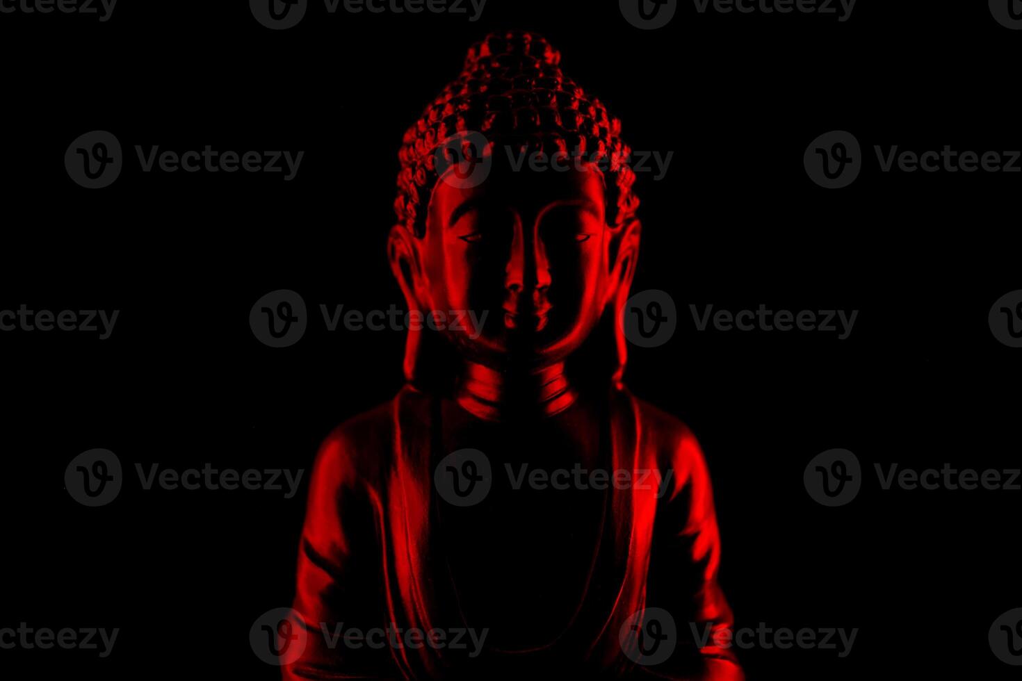 Buddha Purnima and Vesak day concept, Red Buddha statue with low key light against deep black background photo