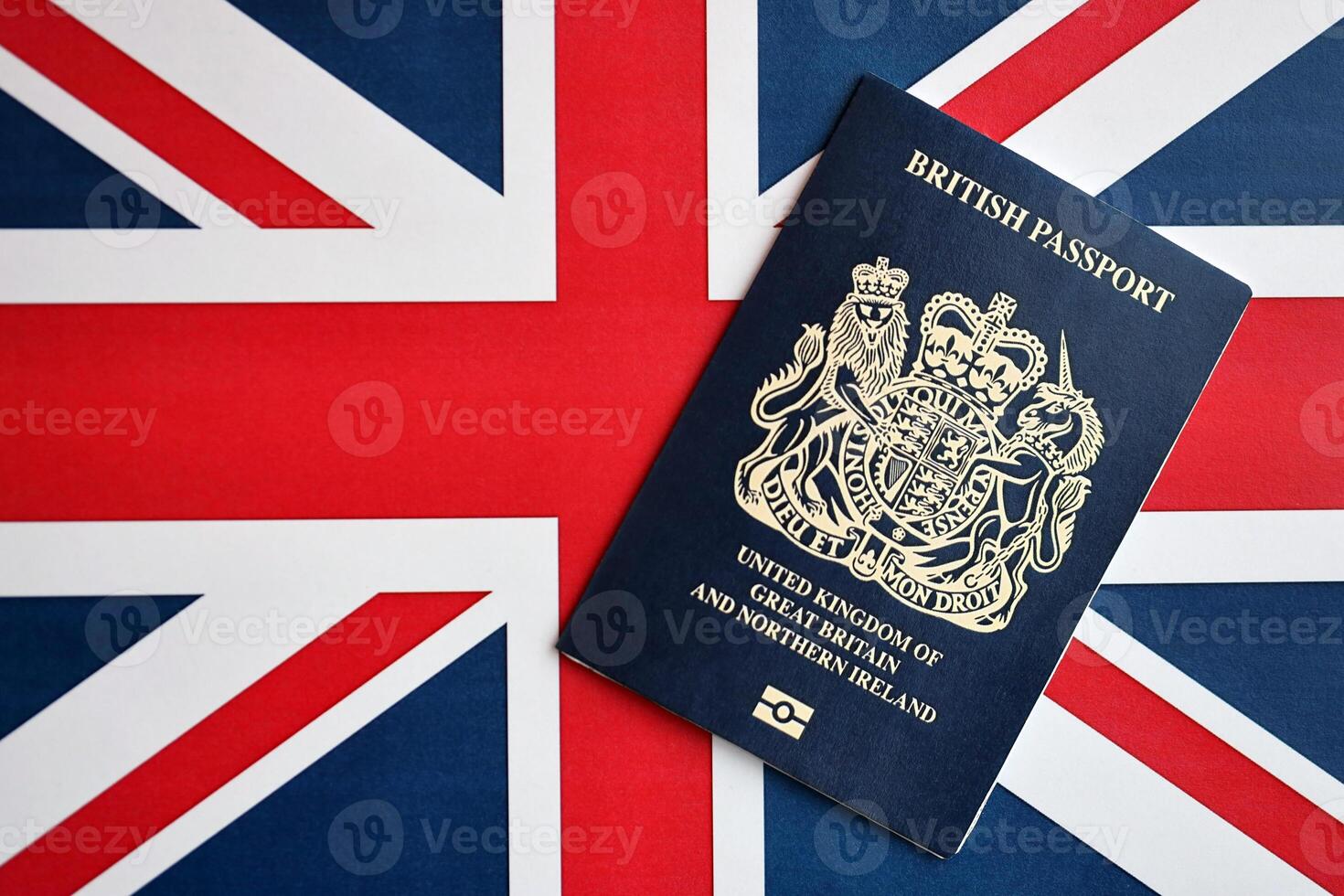 Blue British passport on national flag background close up photo