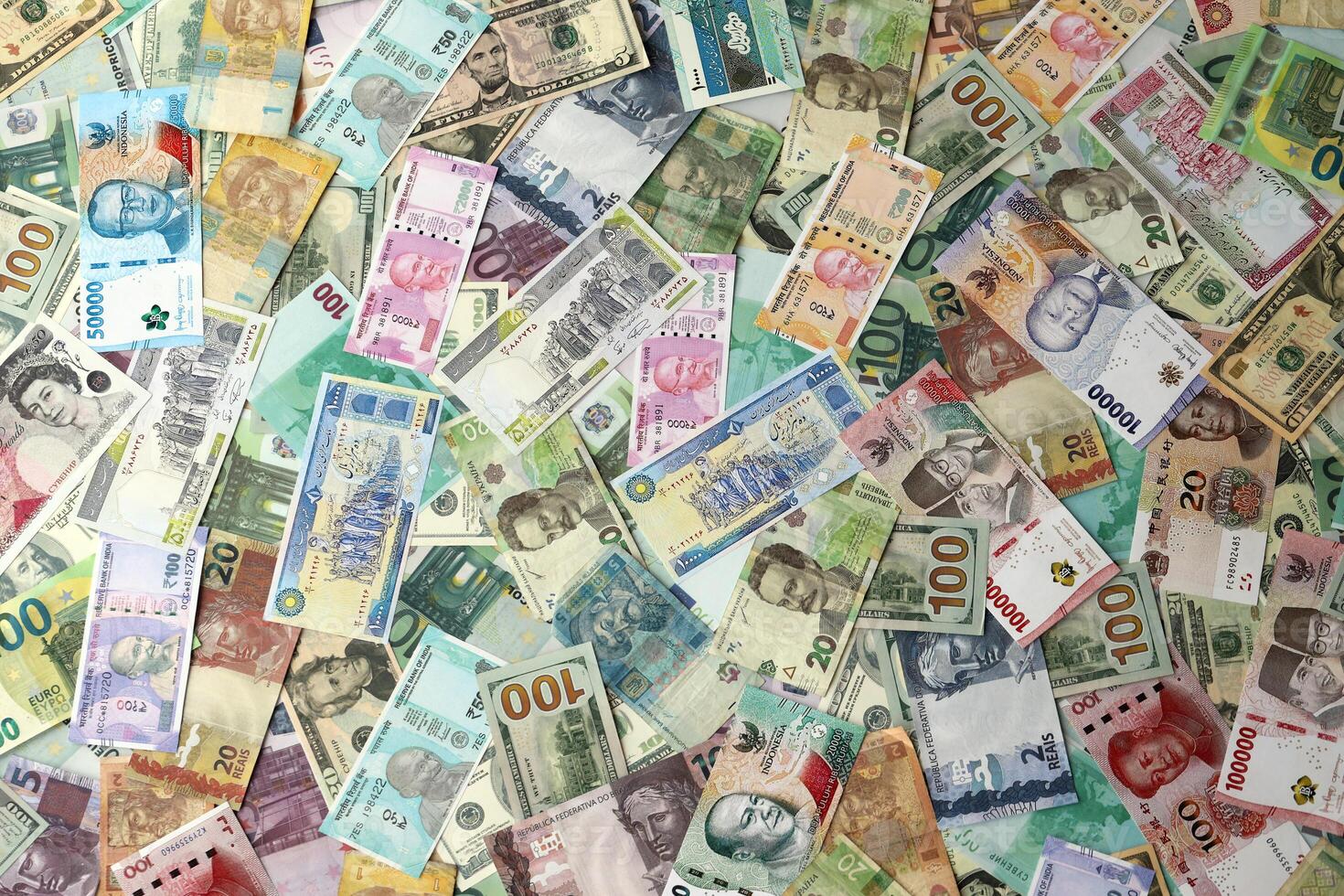Many banknotes of different currency. Background of big amount of random money bills photo