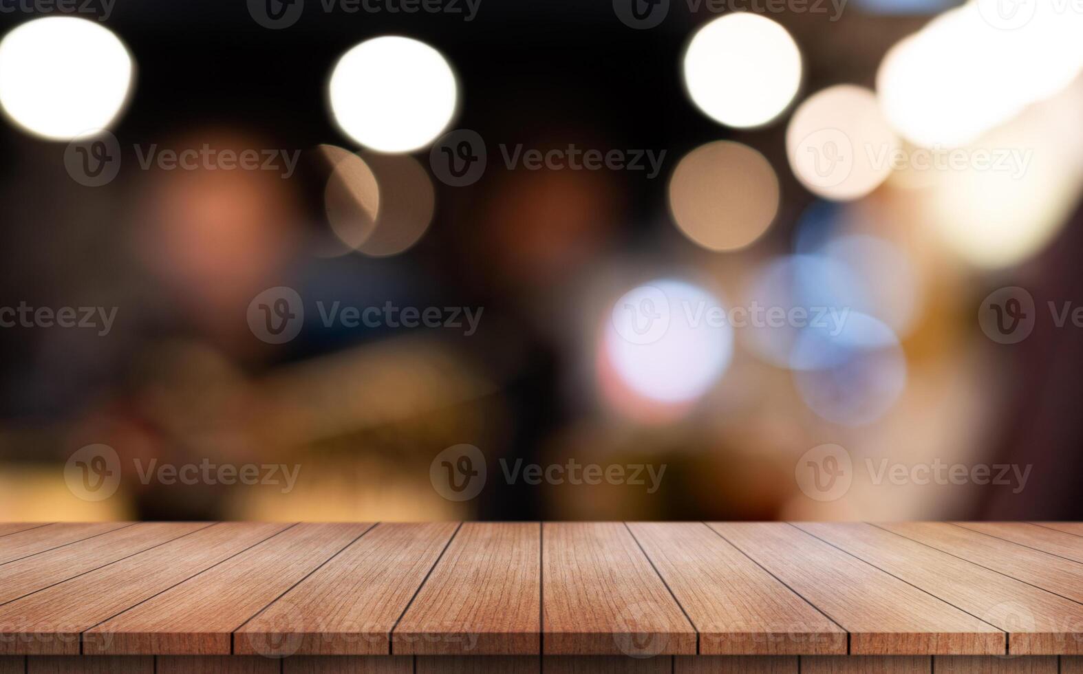 Empty wooden table top with lights bokeh on blur restaurant background photo