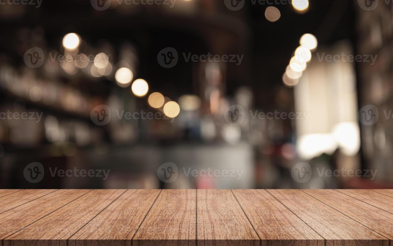 Empty wooden table top with lights bokeh on blur restaurant background photo