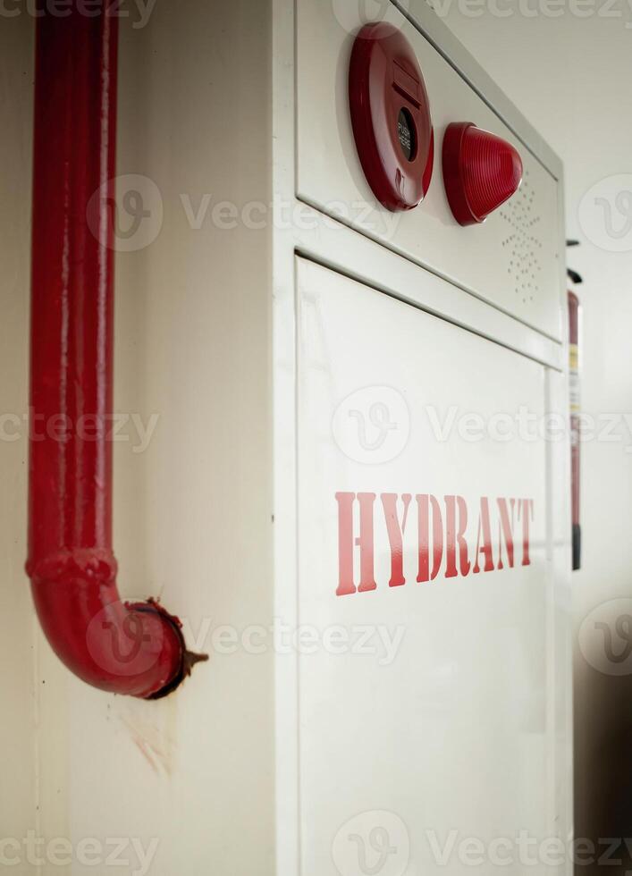 Fire extinguisher and water pump system on wall background, powerful emergency equipment for industry and residential photo