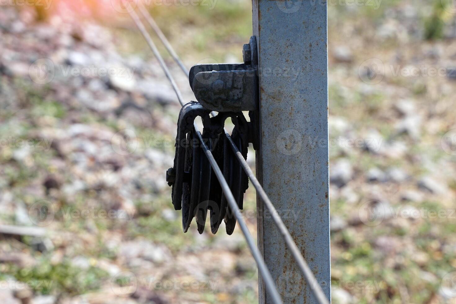 A wire rope that runs through a pulley next to a railroad track. Wire rope used to pull various equipment such as rail wrenches, derailment machines. This cable will lead to the control room. photo