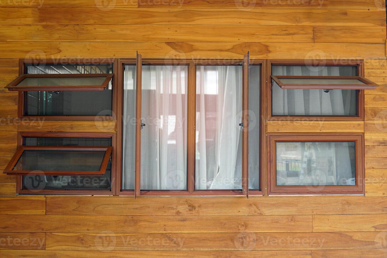 de madera enmarcado vaso ventana. allí son ambos doble ventanas diseñado a ser en el medio. el izquierda y Derecha lados son toldo ventanas, 2 en cada lado, arreglado en parte superior y fondo posiciones. foto