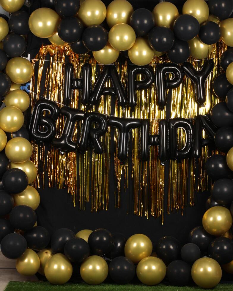 Beautiful decorated happy birthday background with golden and black balloons for photography purposes photo