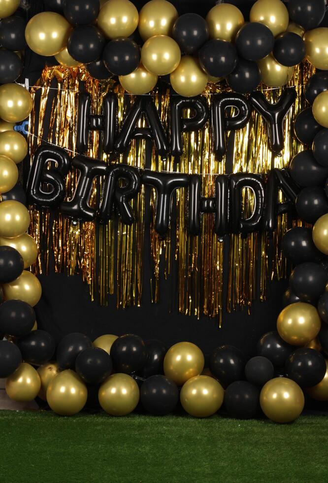 Beautiful decorated happy birthday background with golden and black balloons for photography purposes photo