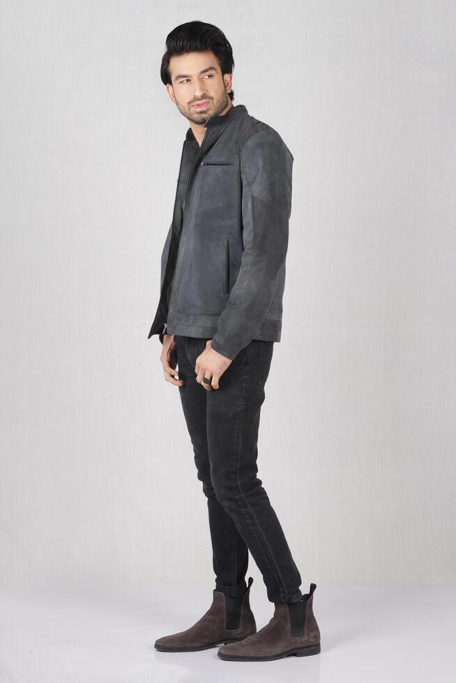 handsome young man wearing a leather jacket and posing in the studio. photo