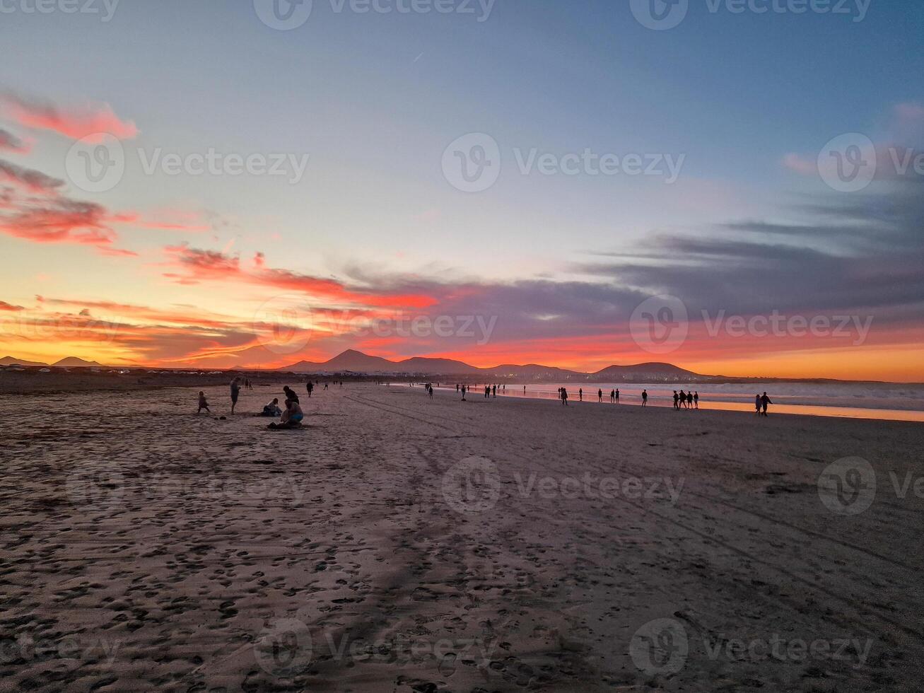 puesta de sol a playa Delaware famara, lanzarote, pinturas el cielo con vibrante matices, fundición un fascinante resplandor terminado el horizonte. asombroso visión ese capturas el esencia de tranquilidad y natural belleza. foto