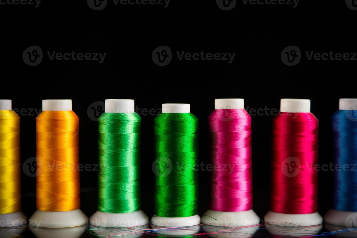 set of different color sewing threads,on black background. photo