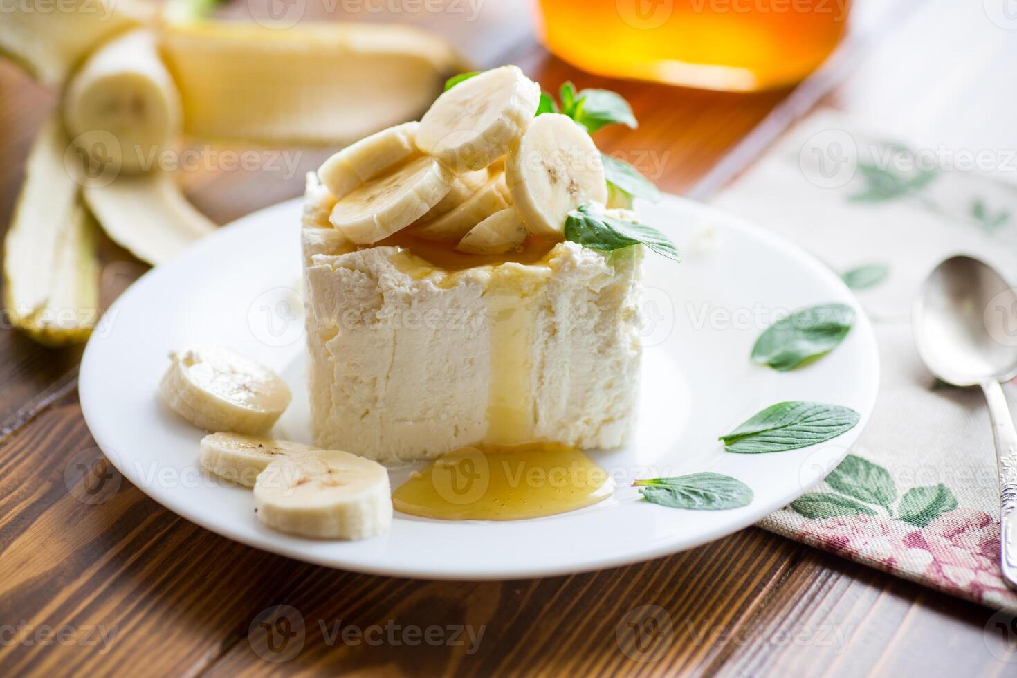 Portion of homemade milk curd with banana slices and honey photo