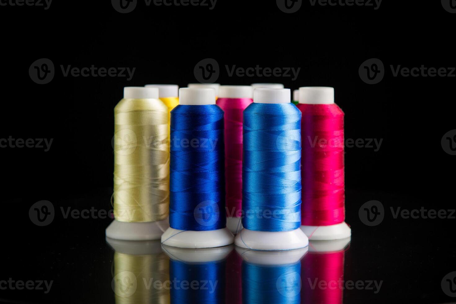 set of different color sewing threads,on black background. photo