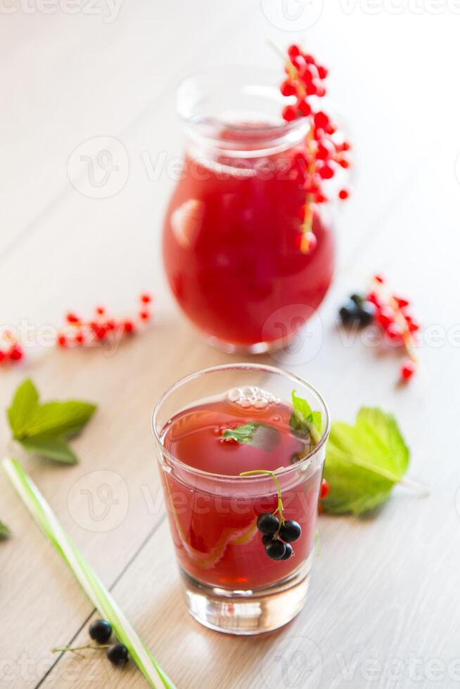 fresh berry juice from red and black currant, on a wooden table photo