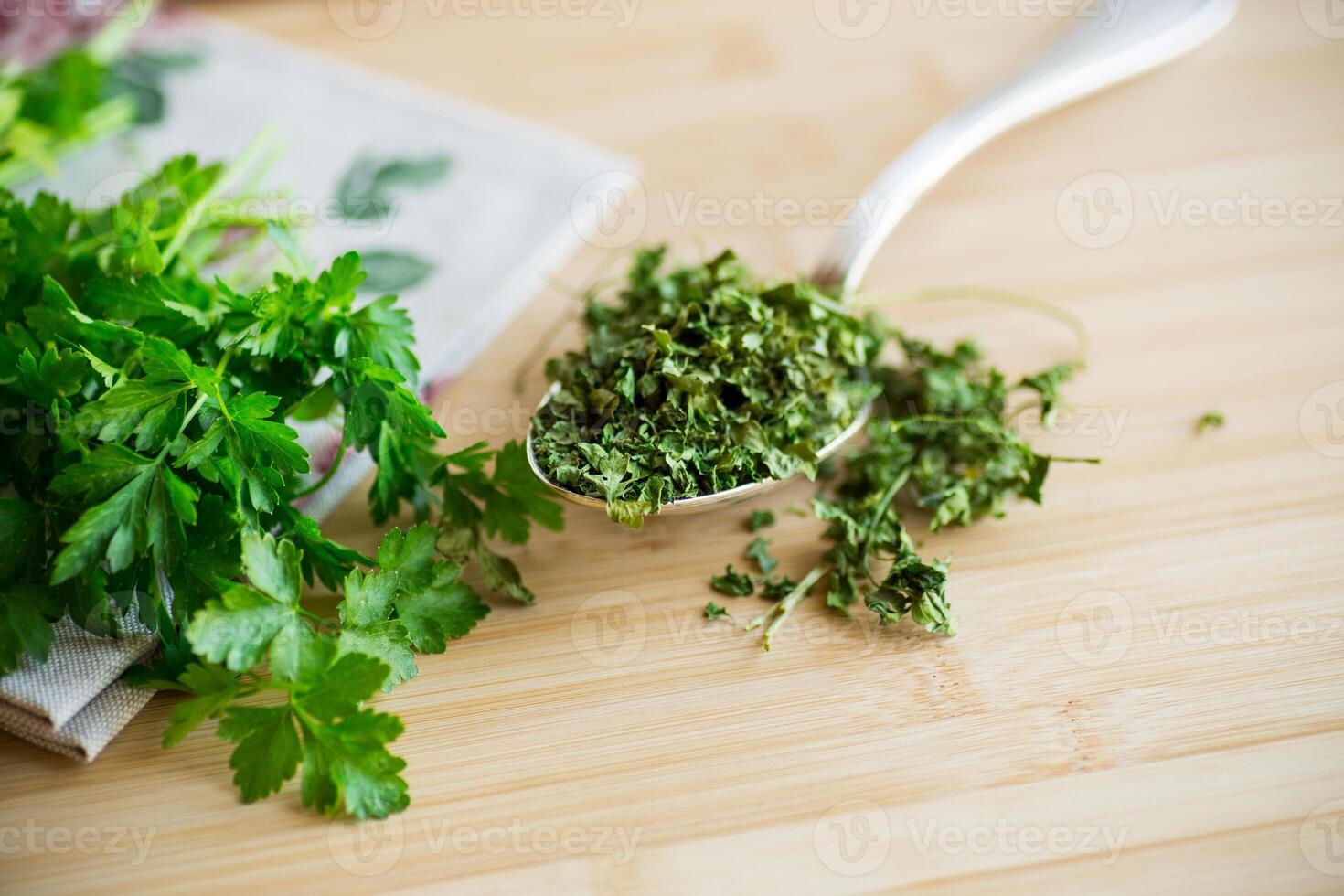 dried parsley in a spoon next to fresh herbs. photo